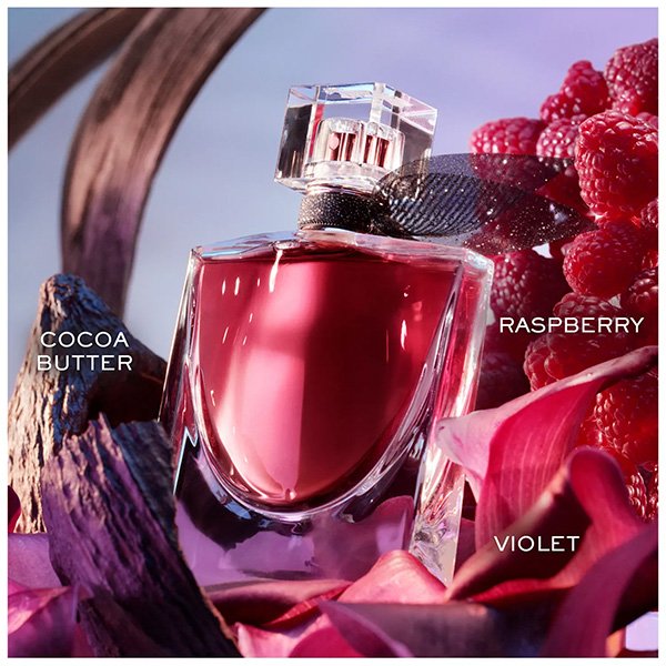 Eau de Parfum Lancôme La Vie Est Belle L'Elixir surrounded by raspberry, cocoa butter, and violet petals
